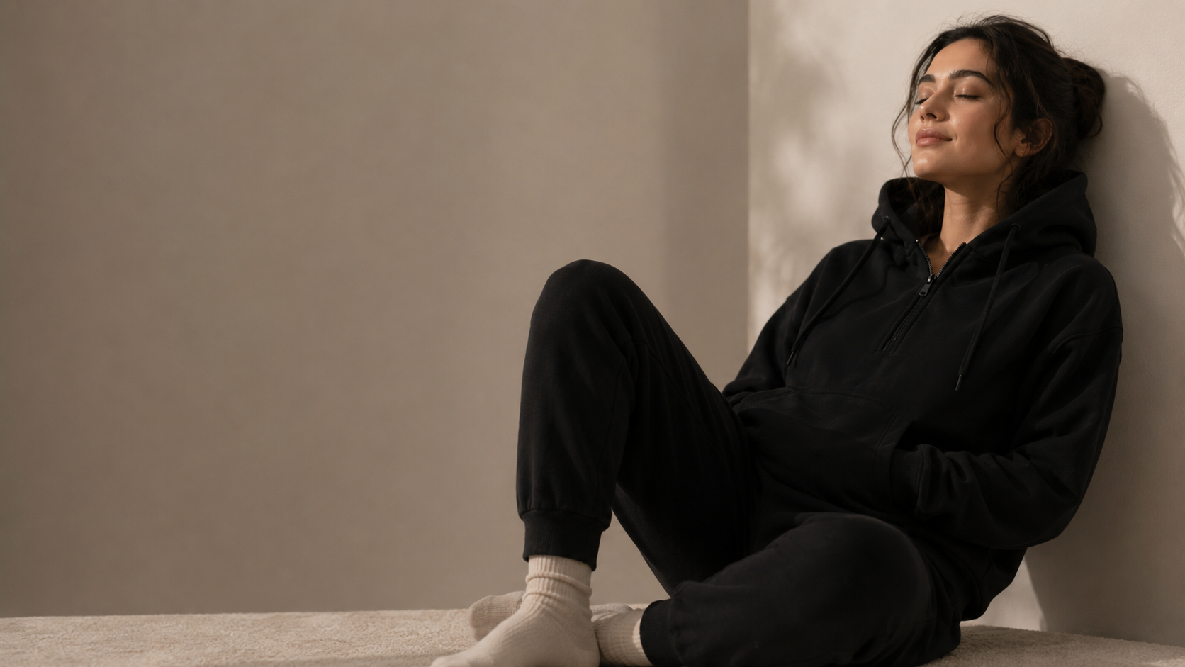 Person wearing weighted hoodie from 247calm  sitting against a beige wall