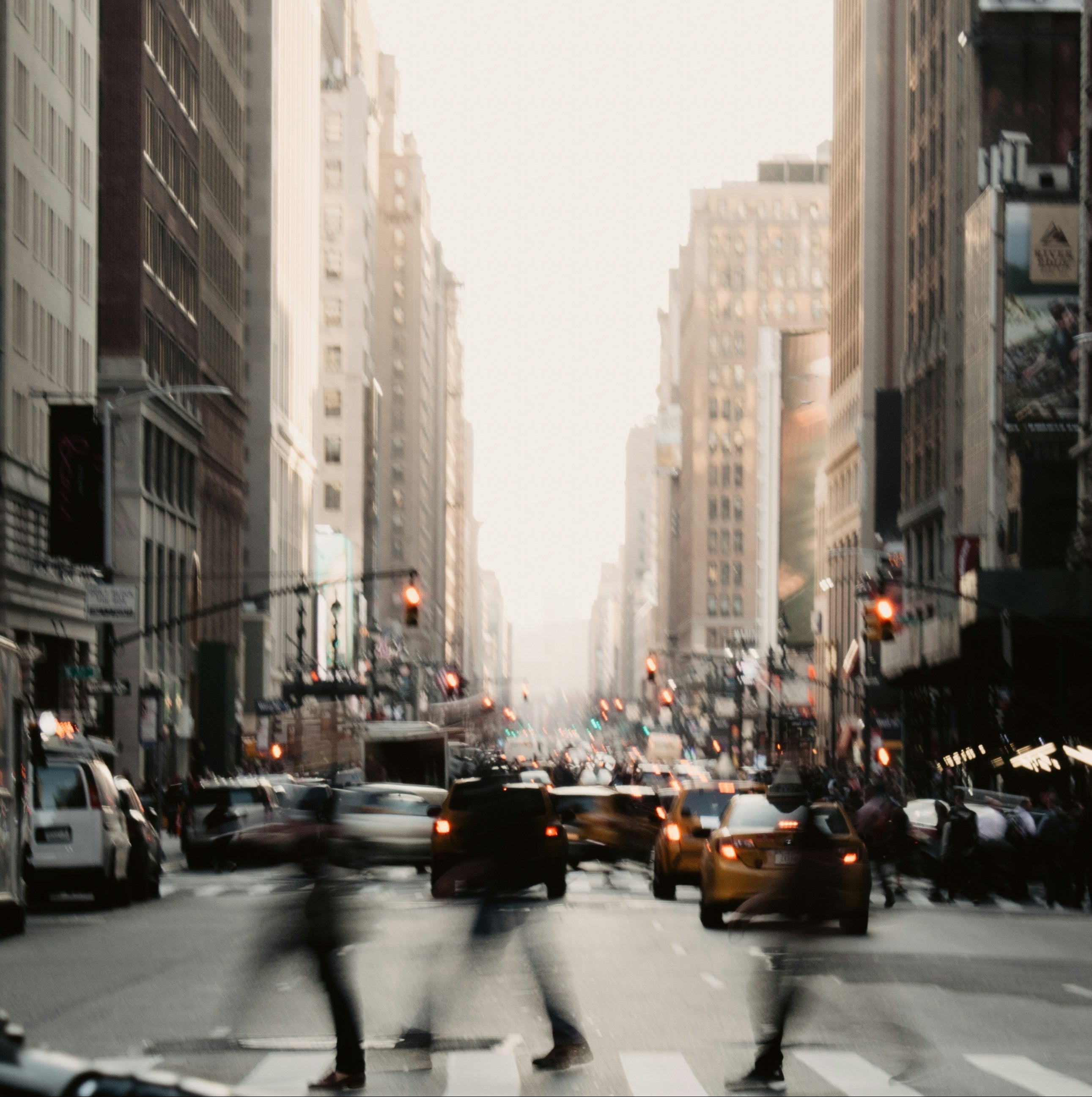 Busy city street with tall buildings and pedestrians in a bustling urban environment.